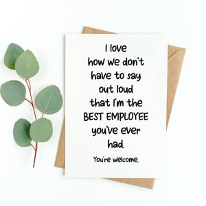 May include: A white greeting card with black text that reads: I love how we don't have to say out loud that I'm the BEST EMPLOYEE you've ever had. You're welcome. The card is placed on top of a brown envelope next to a green eucalyptus branch.