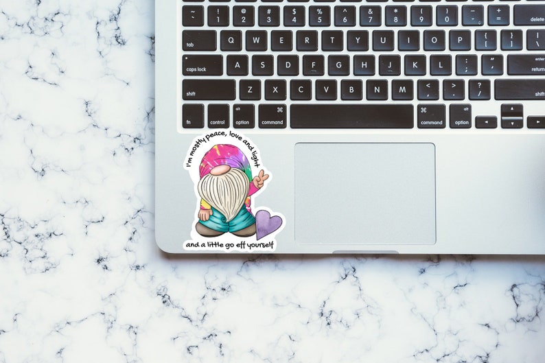 May include: A sticker featuring a cartoon gnome wearing a tie-dye shirt and holding a peace sign. The sticker has the text "I'm mostly peace, love and light and a little go off yourself".