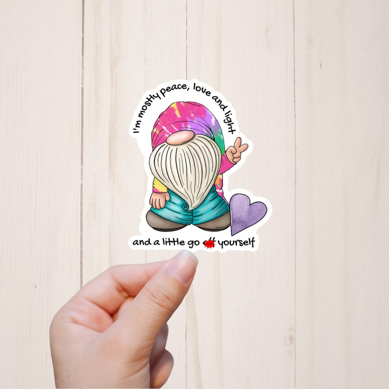 May include: A sticker featuring a cartoon gnome with a tie-dye hat and a peace sign. The gnome is surrounded by the text "I'm mostly peace, love and light and a little go off yourself".