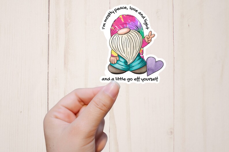 May include: A tie-dye gnome sticker with the text "I'm mostly peace, love and light and a little go eff yourself".