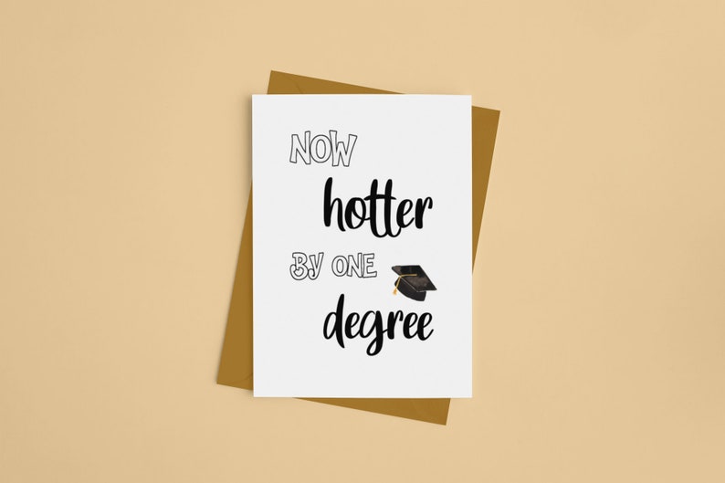 May include: A graduation greeting card with the text "Now hotter by one degree" in black font. A small graduation cap illustration is included. The card is on a brown envelope, set against a beige background.
