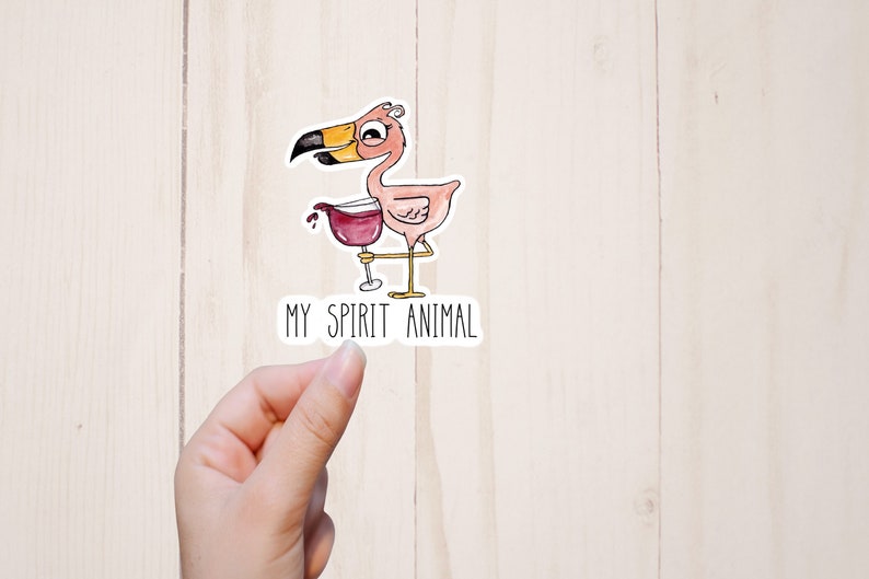 May include: A pink flamingo with a yellow beak is holding a glass of red wine. The text "MY SPIRIT ANIMAL" is below the flamingo.