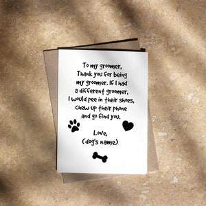May include: A greeting card with a handwritten message to a dog groomer. The message is on a white card with paw prints, a heart, and a bone graphic. The card is inside a brown envelope.