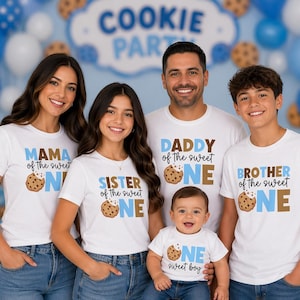 Puede incluir: Una familia de cinco personas con camisetas blancas a juego con texto azul y gráficos de galletas. Las camisetas dicen "MAMA", "DADDY", "SISTER", "BROTHER" y "ONE sweet boy". El fondo presenta globos azules y blancos y una pancarta que dice "COOKIE PARTY".