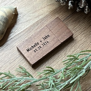 Puede incluir: Una memoria USB de madera con el texto "Michelle + John 05.20.2024" grabado en ella.