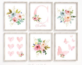 Könnte beinhalten: Set aus sechs gerahmten Aquarelldrucken. Die Drucke zeigen Blumensträuße, Herzen, Schmetterlinge und den Buchstaben "C" mit dem Namen "Charlotte". Die Farbpalette umfasst Rosa-, Blau- und Grüntöne mit goldenen Akzenten. Der Satz "make this day count" steht unten.