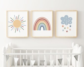 Könnte beinhalten: Drei gerahmte Drucke mit einer Sonne, einem Regenbogen und einer Wolke mit Sternen. Die Drucke befinden sich in einer Kinderzimmerumgebung mit einem weißen Kinderbett und einem Banner mit der Aufschrift "make this day count".