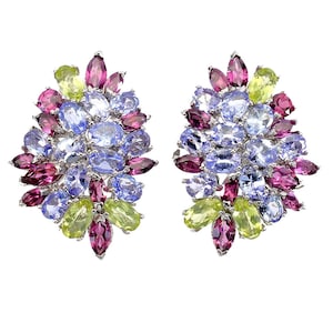May include: A pair of cluster earrings featuring a vibrant arrangement of oval and marquise-cut gemstones in shades of light blue, deep magenta, and lime green, all set in a polished silver-tone metal frame with a dense, multi-faceted floral design.