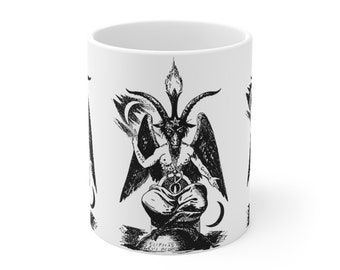 May include: White ceramic mug with a black and white illustration of a goat-headed figure with wings and horns. The figure is sitting on a throne with a pentagram and the text "ELIphas Levi OED" below.