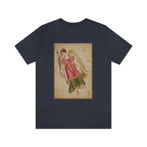 May include: A navy blue t-shirt with a vintage illustration of the constellation Virgo. The illustration features a woman with wings and a pink dress, surrounded by stars.