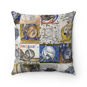 May include: A decorative pillow featuring a patchwork design of medieval illustrations of cats in various poses. The background is a cream color with blue, red, and yellow accents. The pillow is made of a soft, comfortable fabric.