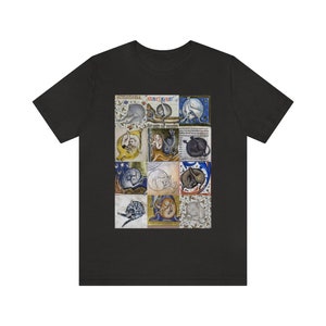May include: A black t-shirt with a collage of 12 medieval illustrations of cats in various poses. The illustrations are in shades of brown, white, blue, and gold, and are set against a yellow background.