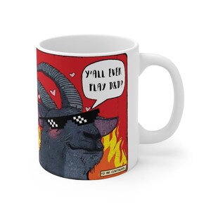May include: White ceramic mug with a comic book style illustration of a black goat wearing sunglasses and a speech bubble that says "Y'all ever play D&D?" The goat is surrounded by flames and hearts.