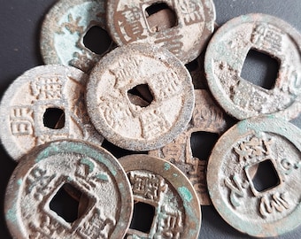 May include: A collection of nine antique Chinese coins with a square hole in the center. The coins are made of bronze and have a patina of age. The coins are arranged in a pile, with some overlapping. The coins have Chinese characters on them.