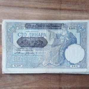 May include: A vintage 100 Serbian dinar banknote featuring a portrait of a woman in a long robe. The note is dated 1 May 1941 and bears the text "Srpska Narodna Banka" (Serbian National Bank).
