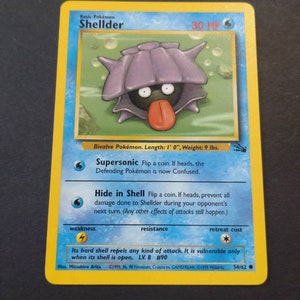Op de afbeelding: Een blauwe en paarse Pokémon-kaart met Shellder, een tweekleppige Pokémon. De kaart heeft een afbeelding van Shellder met zijn schelp open, waardoor zijn zwarte lichaam en rode tong zichtbaar zijn. De tekst op de kaart luidt "Basis Pokémon Shellder 30 HP".