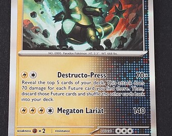 May include: A collectible Iron Thorns trading card featuring a metallic green and black creature with glowing accents. The card displays 140 HP, the Future label, and two attacks: Destructo-Press and Megaton Lariat, with card number 062/162.