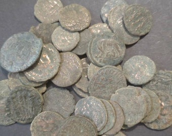 May include: A collection of antique bronze coins with various designs and inscriptions. The coins are worn and tarnished, showing signs of age and use.
