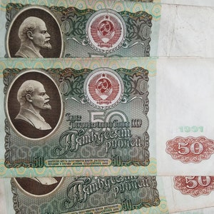 May include: A vintage Soviet Union banknote with a portrait of Lenin and the text "Билет Государственного Банка СССР" (Banknote of the State Bank of the USSR) and "Пятьдесят рублей" (Fifty rubles).