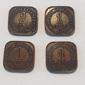 May include: Four antique Straits Settlements 1 Cent coins from 1920. Each coin is square with rounded corners and a bronze finish. The text "STRAITS SETTLEMENTS" encircles the coin's edge, with "1 CENT 1920" in the centre.