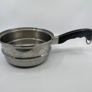 May include: A stainless steel steamer pot with a black handle. The pot has a removable insert for steaming food.