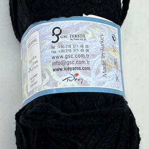 May include: A black skein of 100% acrylic yarn with a label that reads "GSC TEKSTİL Dış Ticaret Ltd. Şti." and includes contact information, website addresses, and "Made in Turkey".