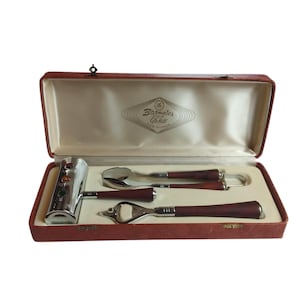 May include: A vintage cocktail set in a red case. The set includes a chrome and wood muddler, spoon, bottle opener, and ice tongs. The case has a cream-coloured interior and a logo that reads "Barmates Globe".