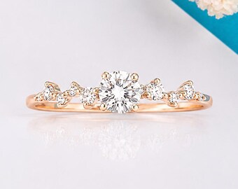 Delicato anello di fidanzamento minimalista in oro rosa con diamanti e motivo floreale.
