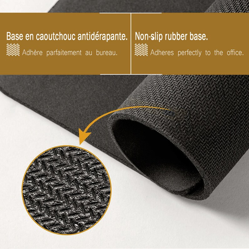May include: Close-up of a black non-slip rubber mouse pad with a textured surface. The text "Base en caoutchouc antid&eacute;rapante. Adh&egrave;re parfaitement au bureau." and "Non-slip rubber base. Adheres perfectly to the office." is visible in the image.