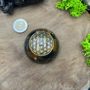 Orgonite artisanale en forme de dôme avec symbole Fleur de vie, oeil de tigre, oeil de faucon et cristal de roche. protection CEM / EMF