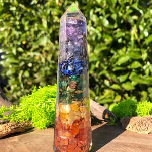 Peut inclure: Une pointe de cristal transparente avec sept couches de pierres précieuses de différentes couleurs, représentant les sept chakras. Les pierres précieuses sont l'améthyste, le lapis-lazuli, l'aventurine verte, la citrine, la cornaline, le jaspe rouge et le quartz clair.