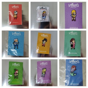 Può includere: Una collezione di spille smaltate con personaggi dei cartoni animati. Ogni spilla è confezionata su una carta con la scritta "Villains need love" e "NAOLITO.COM". Le spille raffigurano personaggi come Jack Skellington, Alice e Goku.