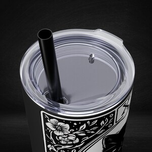a black and white picture of a cup with a straw in it