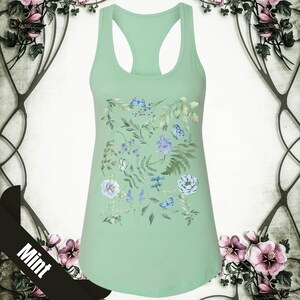 May include: A mint green tank top with a floral print featuring blue and white flowers, leaves, and butterflies.