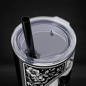 a black and white picture of a cup with a straw in it