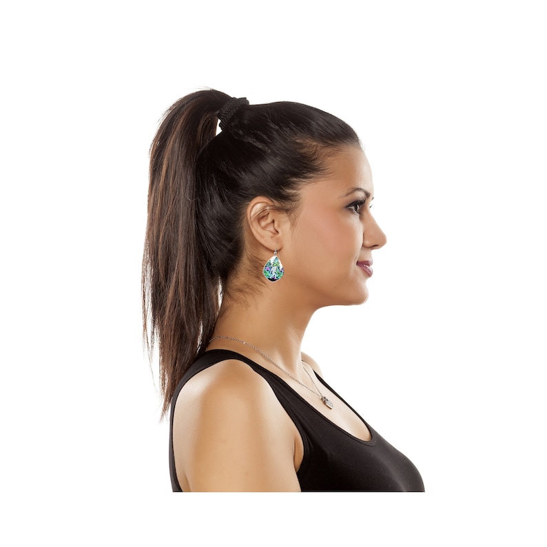 May include: A woman with long dark brown hair pulled back in a ponytail, wearing a black tank top and teardrop-shaped earrings with a green and purple design.