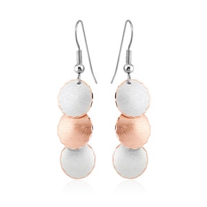 May include: Silver and rose gold tone dangle earrings with three round discs. The top and bottom discs are silver and the middle disc is rose gold.