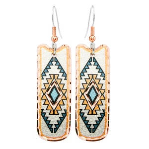 Pode incluir: Um par de brincos pendentes com um padrão geométrico em tons de azul, laranja e branco. Os brincos são feitos de metal com acabamento em cobre.
