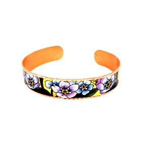 Op de afbeelding: Een koperen armband met een bloemenmotief. De armband is versierd met paarse, gele en groene bloemen op een zwarte achtergrond.