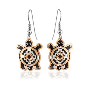 May include: A pair of silver dangle earrings featuring a black turtle with a geometric design in copper and silver. The turtle is a symbol of longevity and wisdom in many cultures.