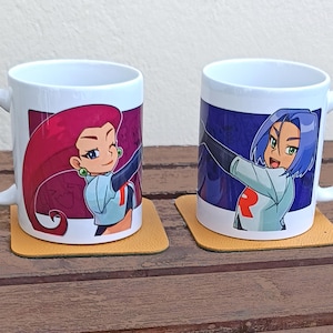 Könnte beinhalten: Zwei weiße Keramikbecher mit Illustrationen von Zeichentrickfiguren. Ein Becher zeigt eine Figur mit roten Haaren, der andere mit blauen Haaren. Beide Becher stehen auf quadratischen gelben Untersetzern, die auf einer Holzoberfläche platziert sind.