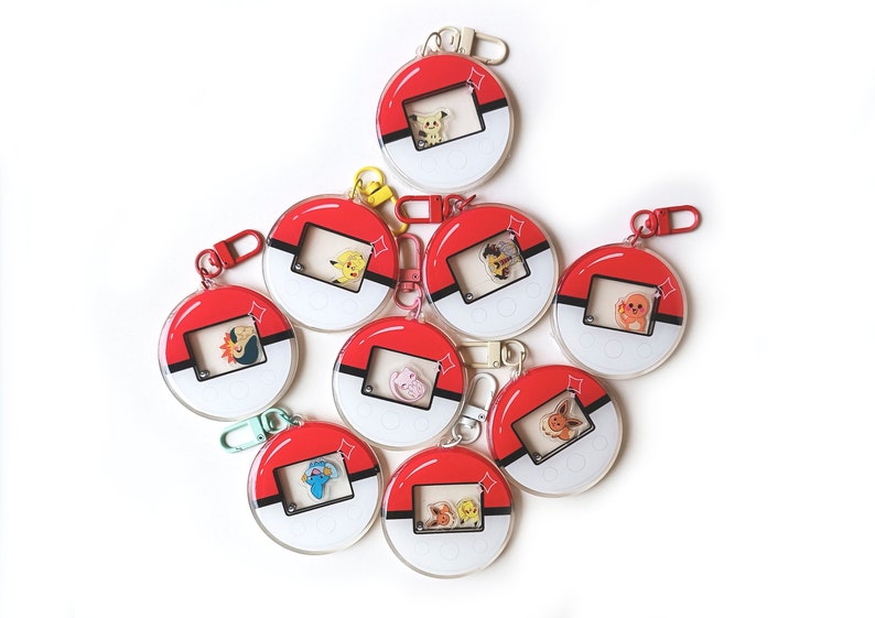 May include: Eight red and white Pokeball keychains with different Pokemon characters inside. Each keychain has a silver ring and a clear plastic cover.