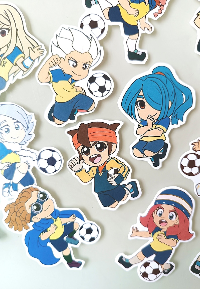 May include: A set of nine colorful cartoon stickers featuring characters playing soccer. The characters are wearing yellow and blue uniforms and have different hairstyles and facial expressions. Each sticker includes a soccer ball.