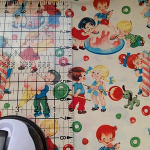May include: Fabric with a repeating pattern of vintage-style children, ice cream, and candy. The children are depicted in various poses, with red, blue, and yellow clothing. The background is a cream color with red and green circles.