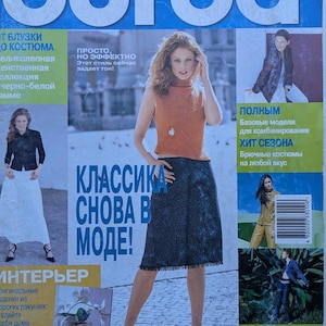 May include: A Burda magazine issue 8/2000 with a blue header and white text. The cover features a person wearing a sleeveless orange knit top and a dark textured knee-length skirt. Additional smaller images show various clothing items and text.