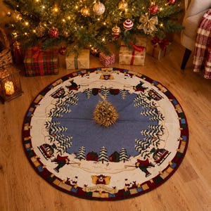 Puede incluir: Una falda redonda para árbol de Navidad con un diseño de escena invernal. Tiene un centro azul, un borde crema con un patrón de pueblo invernal y un borde exterior rojo. Se ven las palabras "Merry Christmas".
