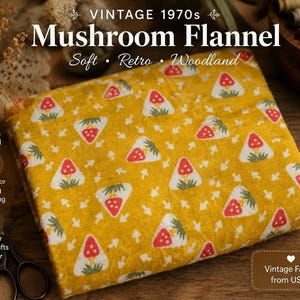 Op de afbeelding: Gele vintage jaren 70 mushroom flanellen stof. De stof heeft een herhalend patroon van rode en witte paddenstoelen op een gele achtergrond. De tekst luidt "Mushroom Flannel" en "100% Cotton Flannel".