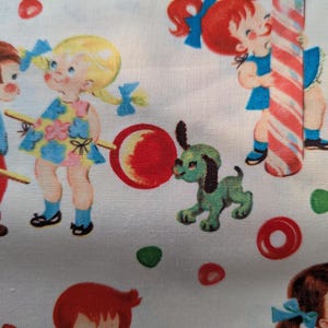 May include: White fabric with a repeating pattern of vintage children, candy, and a green dog. The children are depicted with pigtails and bows, holding lollipops and candy canes. Red, green, and blue accents are used throughout the design.