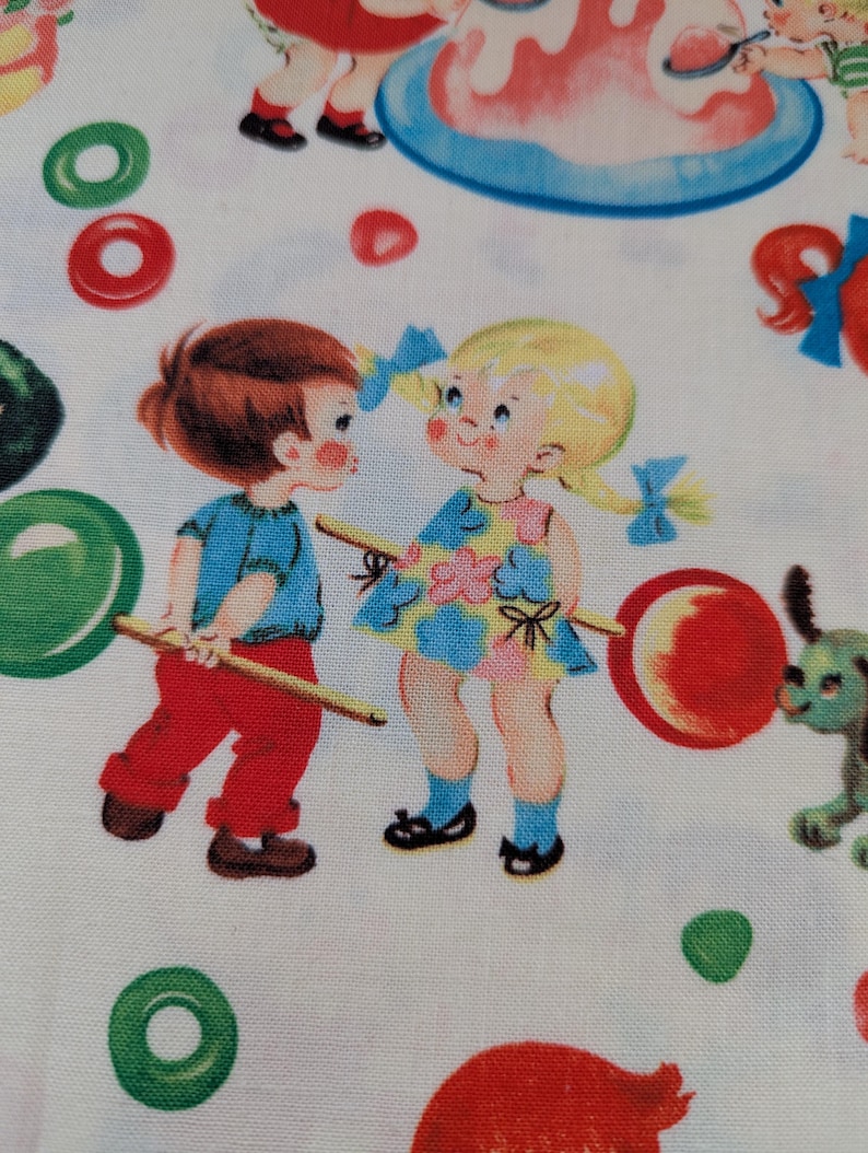 May include: A white fabric with a repeating pattern of vintage children and candy. The children are depicted in colorful clothing, holding lollipops. The candy includes red, green, and pink lollipops and circular candies. The overall design has a retro, whimsical feel.