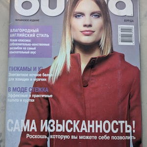 Può includere: Una copertina di rivista con una donna che indossa una giacca rossa. La rivista si chiama "Burda" e il testo della copertina recita "La massima raffinatezza! Il lusso che puoi permetterti." La rivista è una pubblicazione ucraina e il numero è 10/2003.